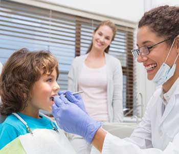 Dentist checking baby boy's mouth