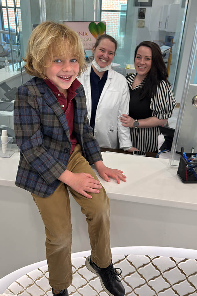 A kid with dental staff at Virginia Biological Dentistry, VA